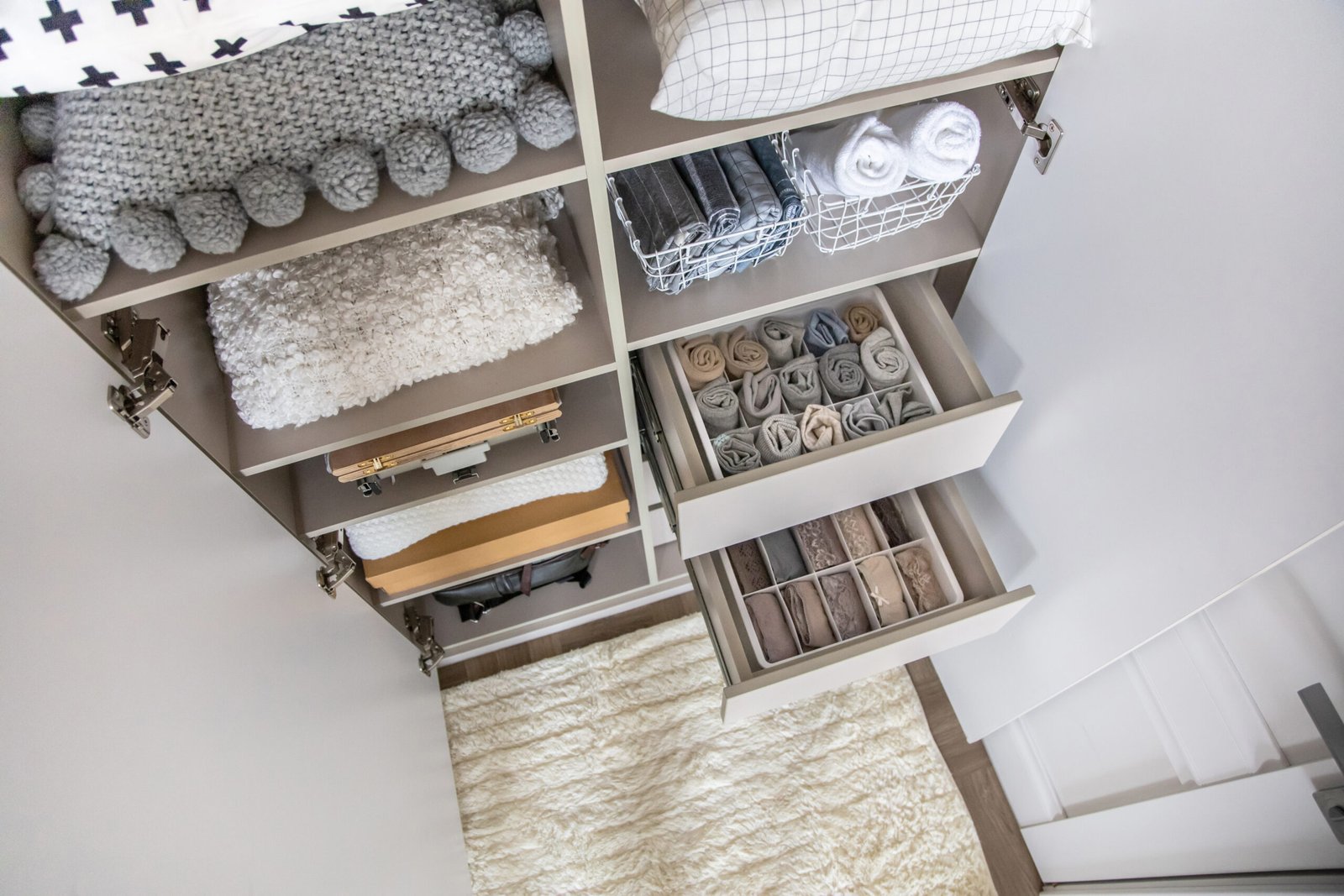 Small bedroom wardrobe storage with divided drawers and organised shelves